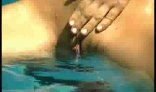 Femme riche qui se met des doigts au bord d'une piscine